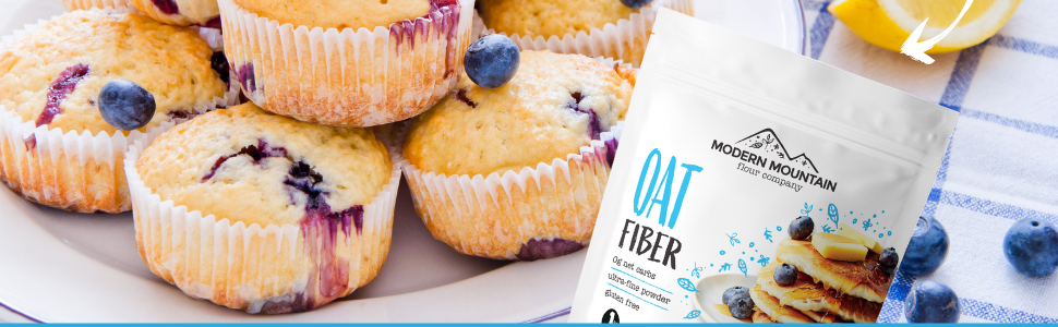 A pouch of Modern Mountain Oat Fiber on top of a pile of blueberry muffins made with oat fiber